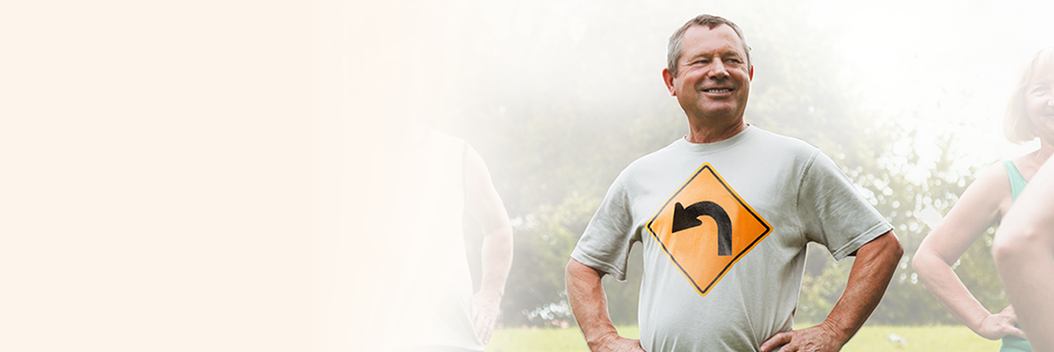man standing outside wearing a shirt with an arrow sign