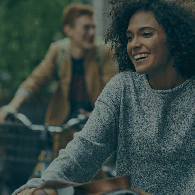 Two people riding bicycles with blurred faces