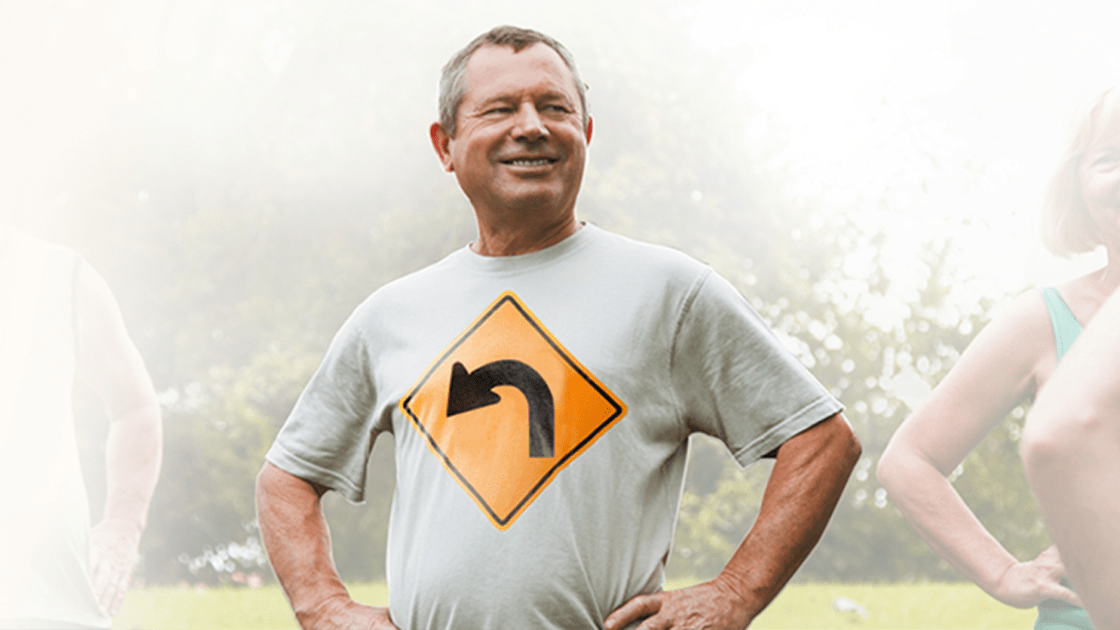 man standing outside wearing a shirt with an arrow sign